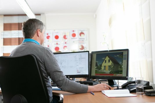 Baugenehmigung-Bauantrag-Ratgeber-Town-Country-Haus-07 Mann vor zwei Computerbildschirmen